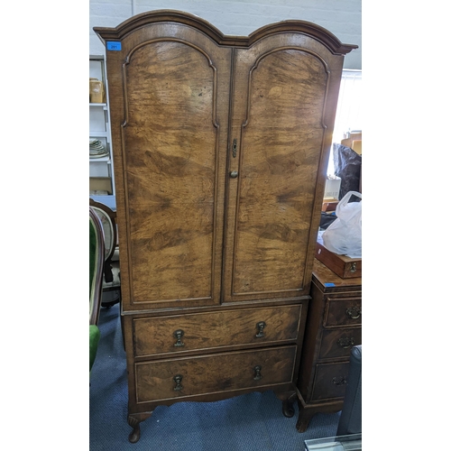 281 - An early 20th century Queen Anne Style walnut veneered cabinet having two doors above two drawers an... 