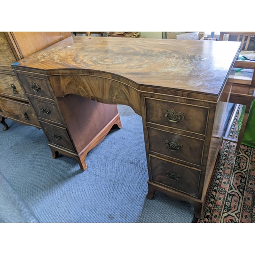 282 - A mid 20th century walnut desk having a central bow drawer flanked by six drawers 74cm h x 108 cm w
... 