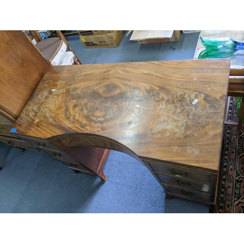 282 - A mid 20th century walnut desk having a central bow drawer flanked by six drawers 74cm h x 108 cm w
... 