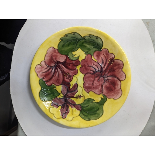 40 - An early 20th century Moorcroft Hibiscus pattern plate A/F decorated with floral design on a yellow ... 