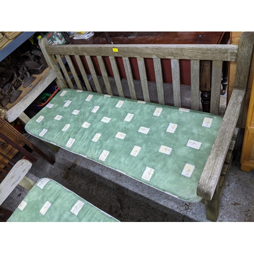 A Lister slatted teak garden table 71cm x 119cm x 70.5cm and two matching benches with loose seat c
