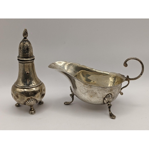 108 - An early 20th century silver sauce boat, together with a silver pepper shaker, 104.5g, Location:TABL... 