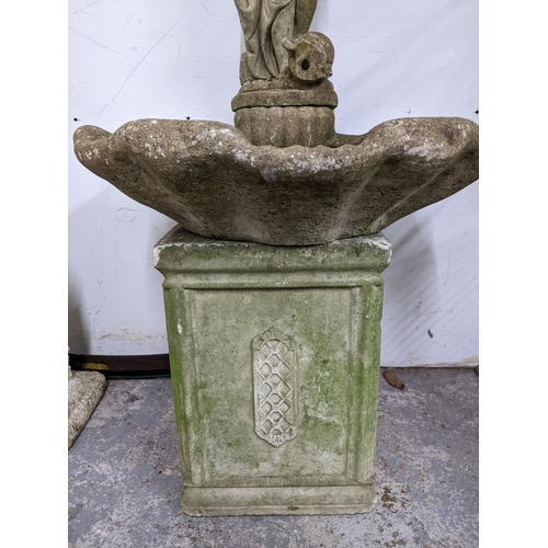 325 - A weathered concrete stone garden fountain in the form of a classically dressed maiden with a vase b... 