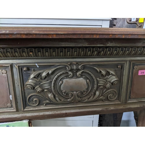 216 - A late Victorian cast iron fire surround having cast scrolled leaf and floral decoration, with two p... 