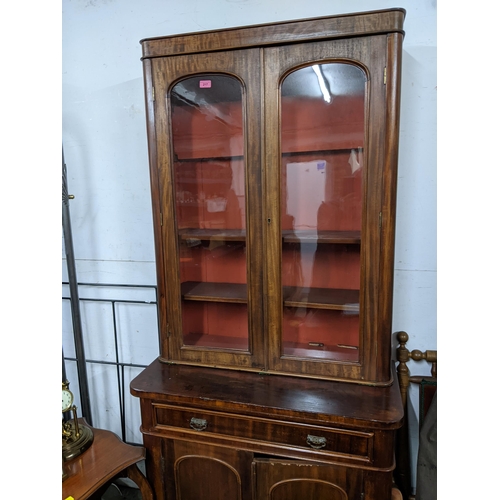 217 - A Victorian mahogany bookcase cabinet with a pair of glazed doors over a drawer and a pair of doors,... 