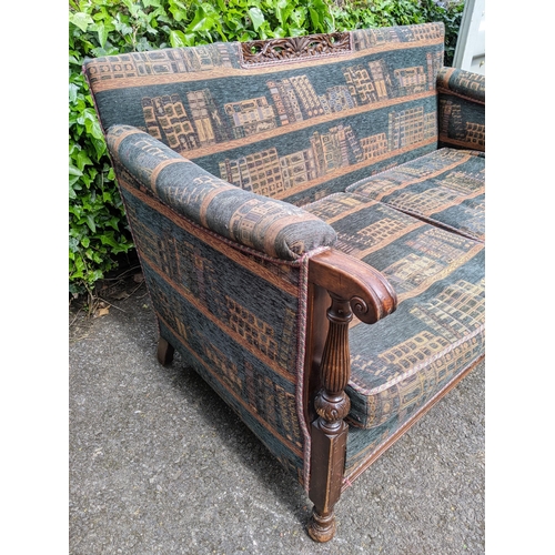 300 - A mid 20th century two seater sofa having a carved top rail, scrolled arms supported by reeded colum... 