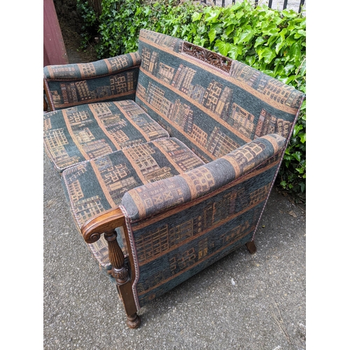 300 - A mid 20th century two seater sofa having a carved top rail, scrolled arms supported by reeded colum... 