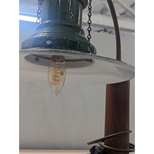 322 - An Industrial style desk lamp having a vintage 1940s green enamel railway lamp shade on a later bras... 