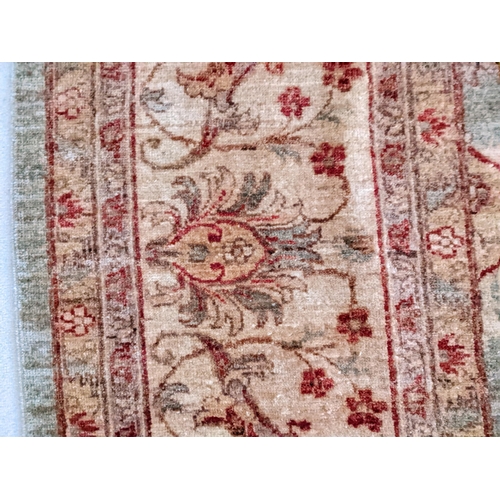 267 - A Zeglar design hand knotted woollen rug with repeated pelmets and vine motifs on a green ground, 28... 