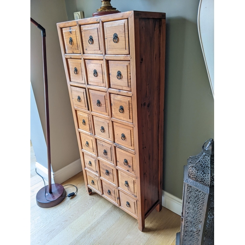 277 - A Chinese pine medicine cabinet with twenty one drawers, with ring handles on shaped feet, 145cm hig... 