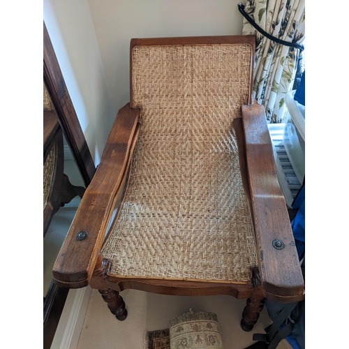 283 - A teak framed plantation chair with a cane back and seat, foldout arms and turned legs
Location: A2B