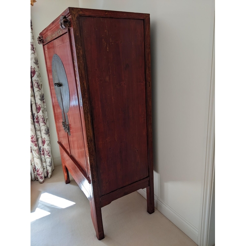 291 - A Chinese red lacquered marriage cabinet with gilt ornament and brass fittings, enclosing shelves an... 