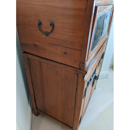 292 - A Chinese pine black lacquered, carved cabinet with twin boxed modular units, over a pair of doors, ... 