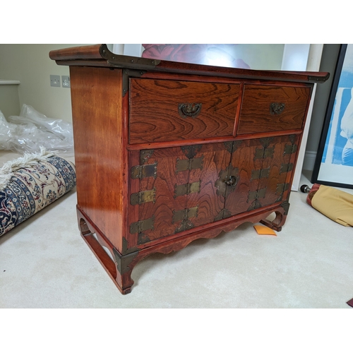 305 - A Korean cabinet with a pair of drawers with brass strapwork ornament, 60cm high, 80cm wide
Location... 