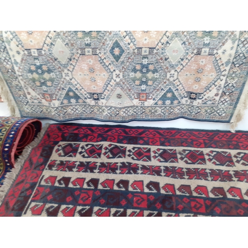 100 - A Persian design rug on a red ground, an Afghan rug and a machine made mat. Location:A4F