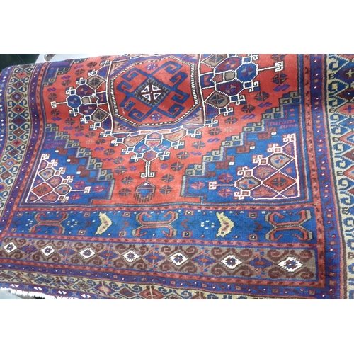 100 - A Persian design rug on a red ground, an Afghan rug and a machine made mat. Location:A4F