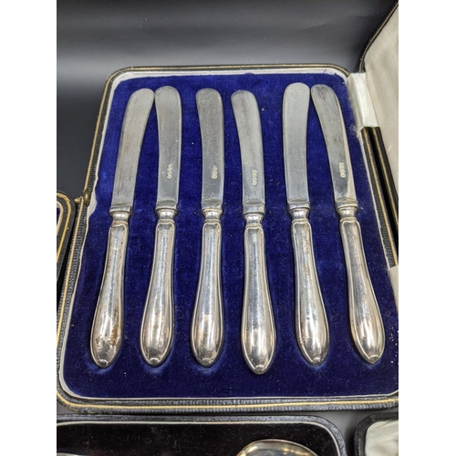 110 - A set of six silver coffee spoons, 50.5g and silver handled knives along with other flatware
Locatio... 