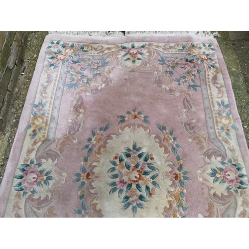 112 - A Chinese pink ground rug having a central motif and a floral design, 250c,m x 153cm
Location:G