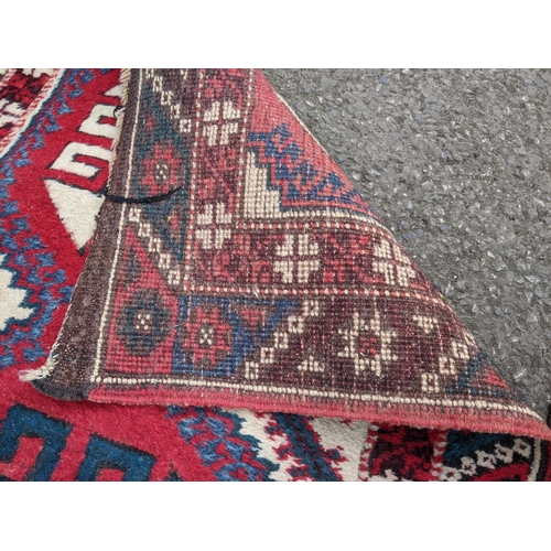 114 - A matched pair of Persian hand woven runners having a red ground with repeating motifs, 284cm x 72cm... 