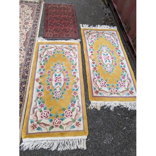 115 - Four mixed rugs to include a pair of Chinese yellow ground rugs, 128cm x 61cm, an Indian beige groun... 