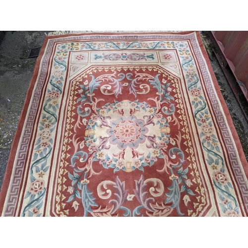 116 - A Chinese red ground rug having a central motif and multi-guard borders, 280cm x 182cm
Location:G