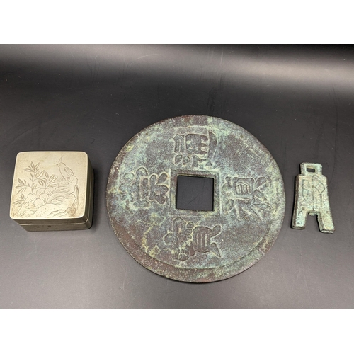 142 - Two Chinese tokens to include a large example with square shaped hole and raised character marks, to... 