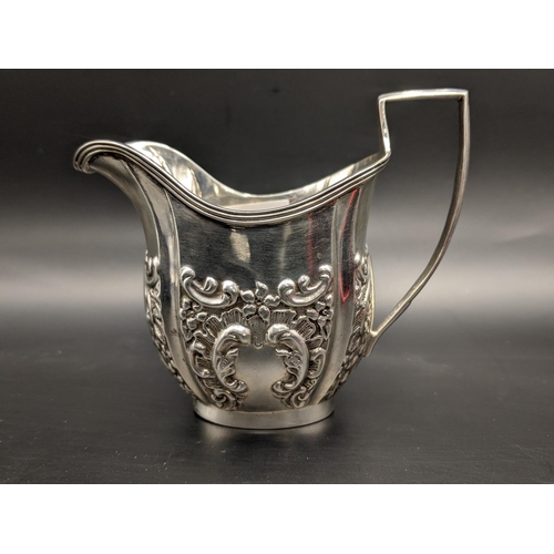 152 - An early 20th century silver cream jug with embossed floral decoration, hallmarked Chester 1906, 60.... 