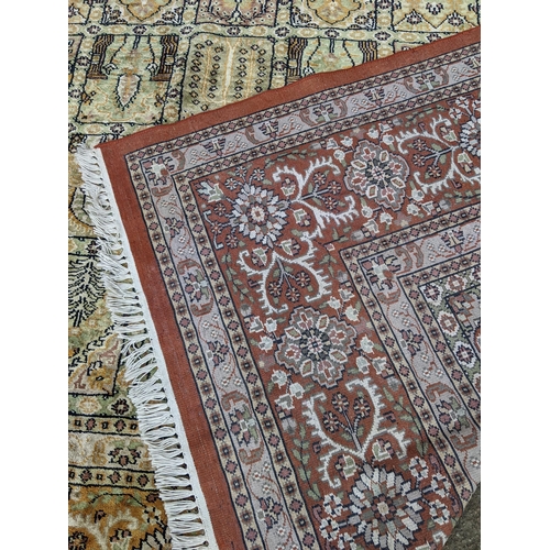 204 - A handwoven silk Turkish carpet having geometric designs with multi guard borders and tasselled ends... 