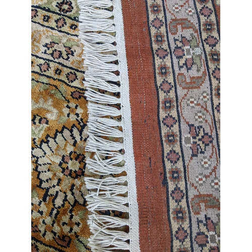 204 - A handwoven silk Turkish carpet having geometric designs with multi guard borders and tasselled ends... 