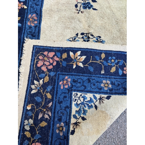 205 - A Chinese handwoven Peking rug having a central motif and a floral border 180cm x 118cm Location:G