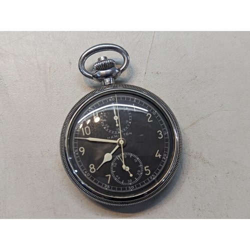 387 - A group of three pocket watches to include a Hamilton having a black dial and subsidiary dials, a Ro... 