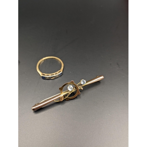 90 - A 9ct gold stick pin brooch set with paste stones together with a yellow metal ring set with diamond... 