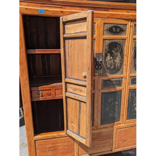 374 - A Chinese black lacquered pine marriage cabinet with four panelled doors decorated with figures and ... 