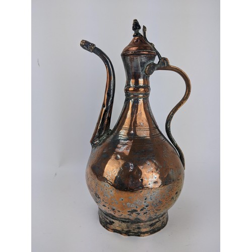 216 - An 18th century Persian copper and brass Dallah, with a hinged lid on curved spout, 36cm high, Locat... 