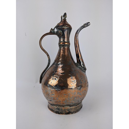 216 - An 18th century Persian copper and brass Dallah, with a hinged lid on curved spout, 36cm high, Locat... 