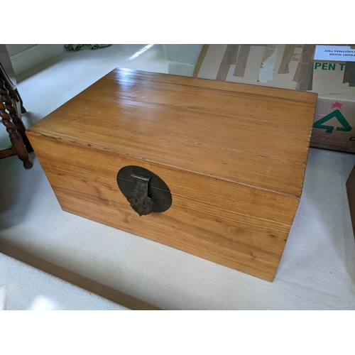 263 - A Chinese polished camphor wood chest with a hinged top, brass clasp and caring handles, 42cm x 93cm... 