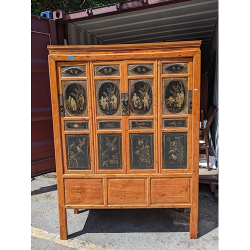 300 - A Chinese black lacquered pine marriage cabinet with four panelled doors decorated with figures and ... 