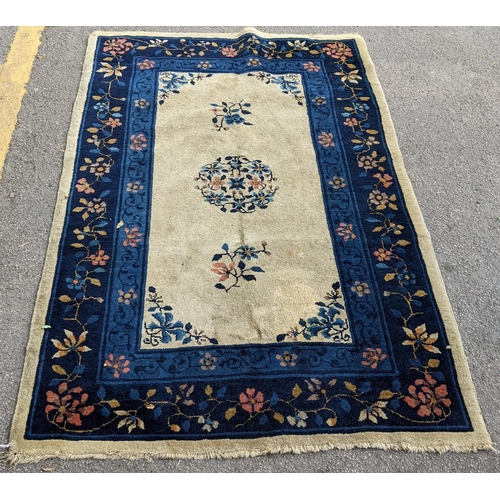 305 - A Chinese handwoven Peking rug having a central motif and a floral border 180cm x 118cm Location:G