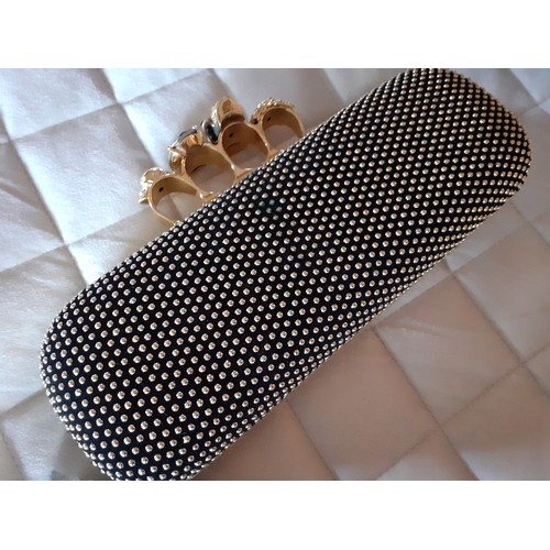 6 - Alexander McQueen-A fabric clutch bag with gold tone four ring knuckle duster clasp with skull and j... 
