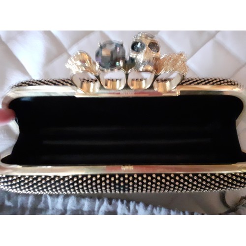 6 - Alexander McQueen-A fabric clutch bag with gold tone four ring knuckle duster clasp with skull and j... 