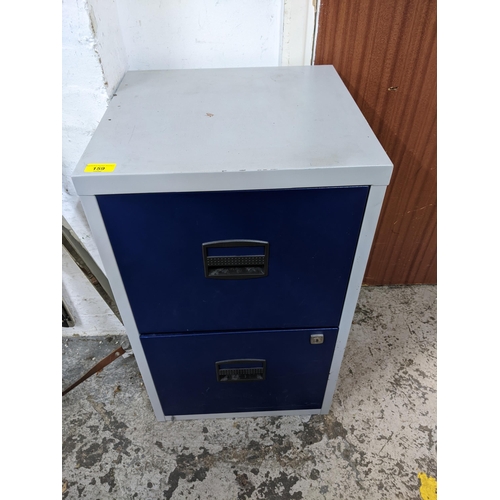 159 - A two-drawer metal filing cabinet, blue finished drawer fronts, and grey painted frame Location:G