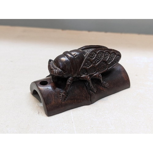 182 - A Japanese treen carved netsuke of a Cicada perched on bamboo
Location:CAB1