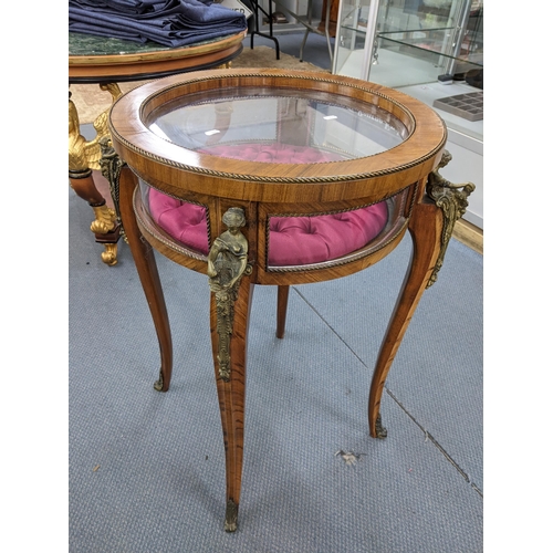 228 - A vintage French circular topped bijouterie display table having applied figural gilt metal mounts a... 