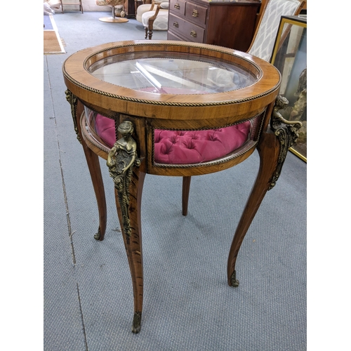 228 - A vintage French circular topped bijouterie display table having applied figural gilt metal mounts a... 