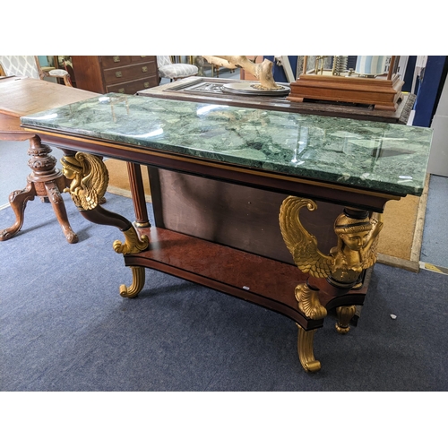 229 - An Empire style rectangular topped console table having a marble effect top supported by two winged ... 