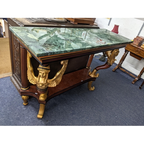 229 - An Empire style rectangular topped console table having a marble effect top supported by two winged ... 