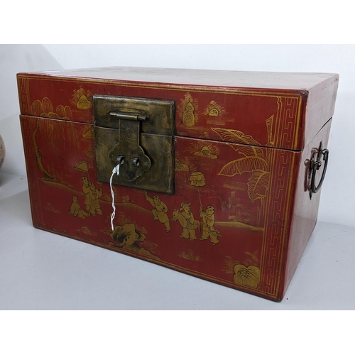 245 - A reproduction Chinese red lacquered twin handled box decorated with scenes of children playing 26cm... 