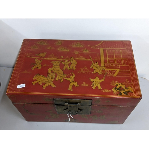 245 - A reproduction Chinese red lacquered twin handled box decorated with scenes of children playing 26cm... 