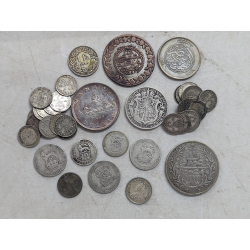 322 - A mixed group of early 20th century coins to include a 1935 Canadian silver Dollar, Egyptian 20-Qirs... 