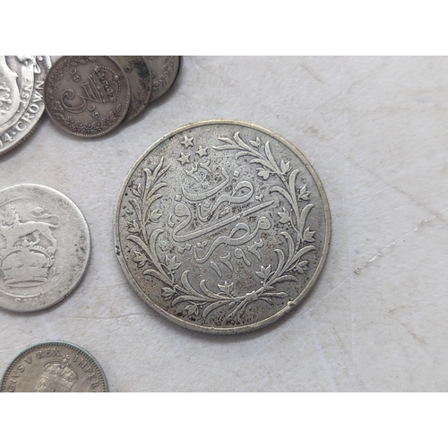 322 - A mixed group of early 20th century coins to include a 1935 Canadian silver Dollar, Egyptian 20-Qirs... 